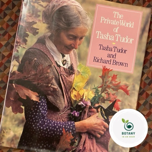 Tasha Tudor standing in her garden with a bouquet of flowers.